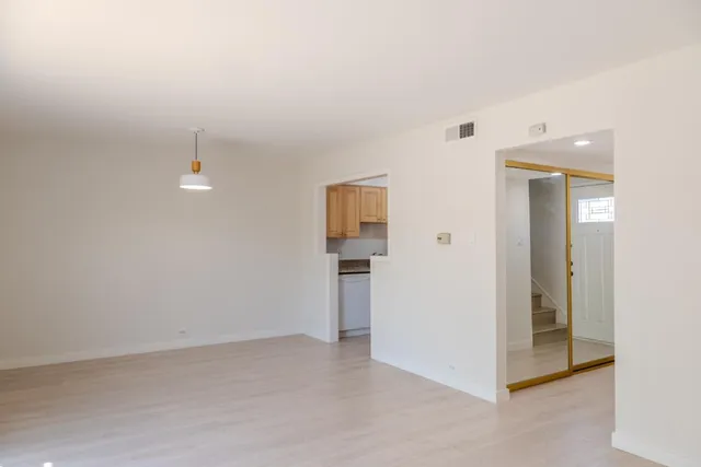 an empty room with closet and windows
