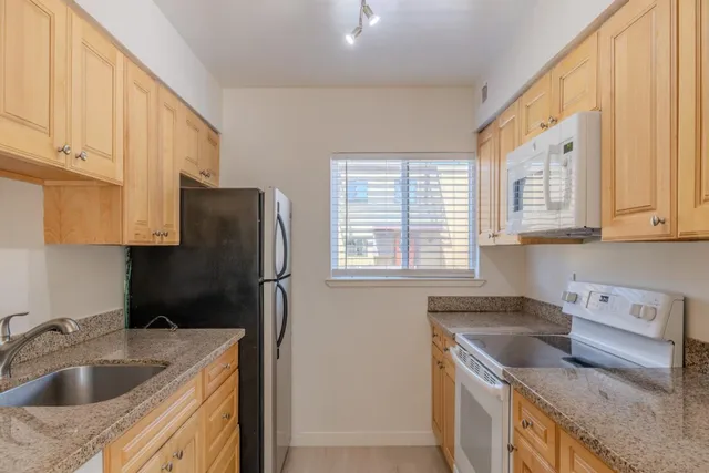 a kitchen that has a sink cabinets counter space and appliances