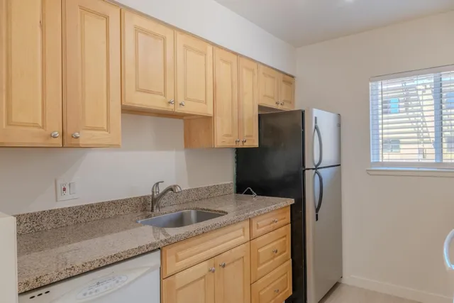 a kitchen with stainless steel appliances granite countertop a refrigerator sink and cabinets