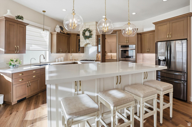 534 East Fish Hatchery Road Mantua, UT 84324 - Photo 1 of 87 Kitchen featuring decorative backsplash, stainless steel appliances, a kitchen island, a kitchen bar, and dual tone cabinets