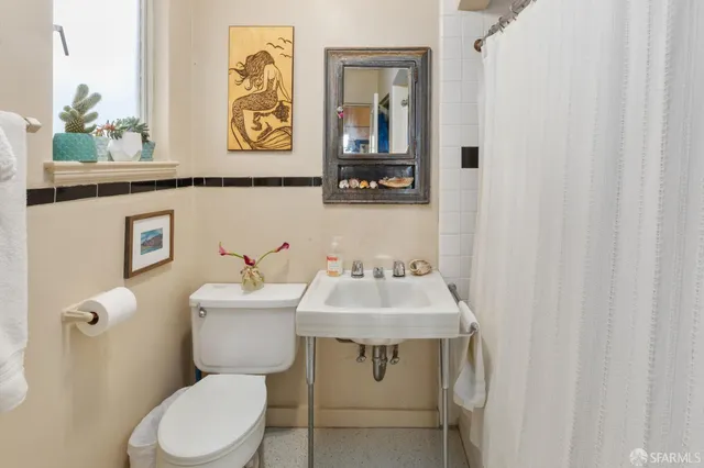 a bathroom with a toilet a sink and a mirror