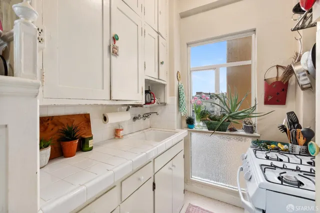 a kitchen with a sink stove and white cabinets