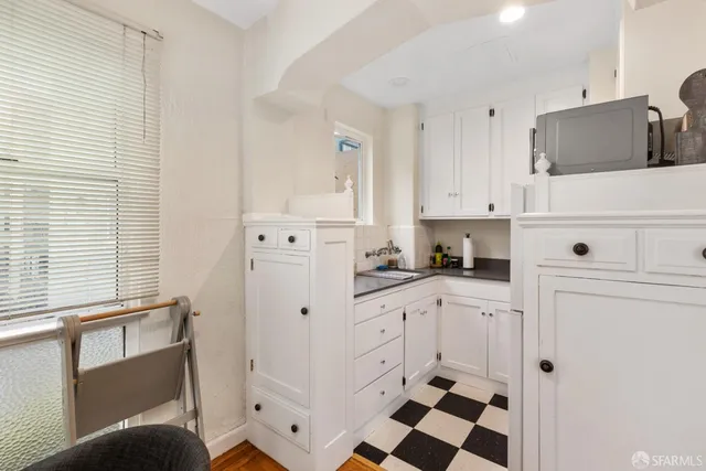 a kitchen with white cabinets and appliances