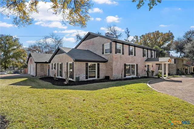 a view of a white house with a yard