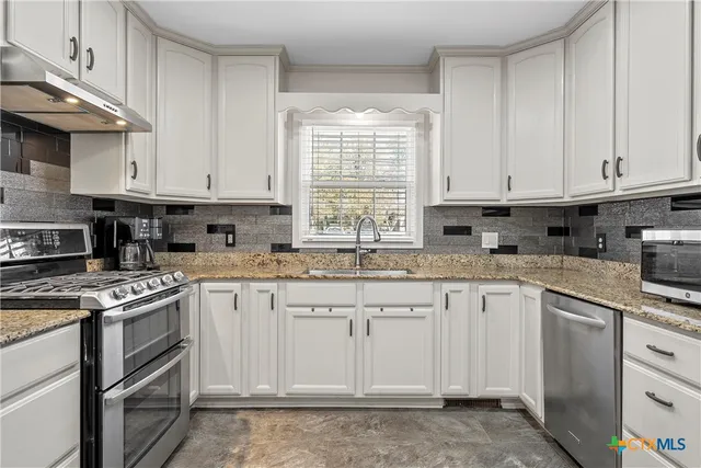 a kitchen with granite countertop white cabinets and white appliances