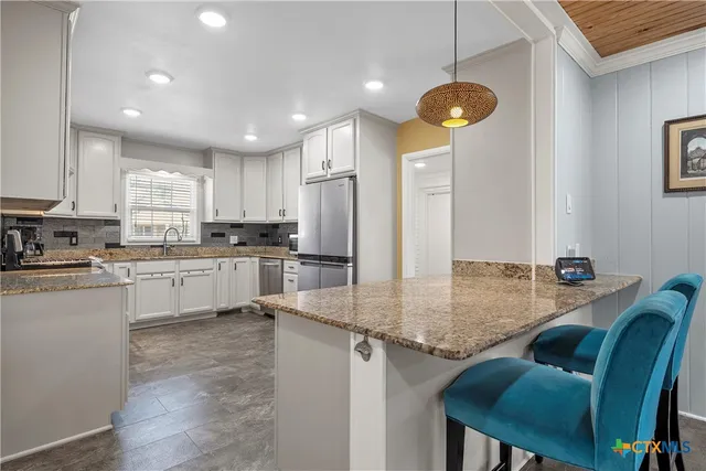 a kitchen with refrigerator cabinets dining table and chairs