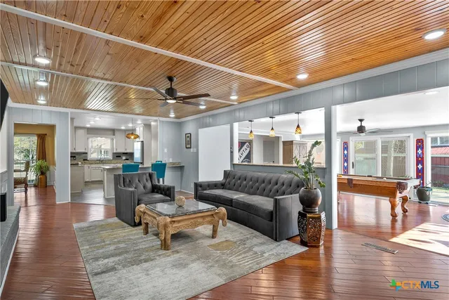a living room with furniture and a wooden floor