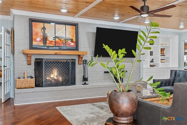 a living room with furniture a chandelier and a fireplace
