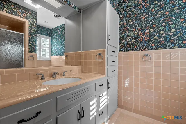 a bathroom with a sink a vanity and a mirror