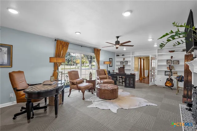 a living room with furniture a fireplace and a large window