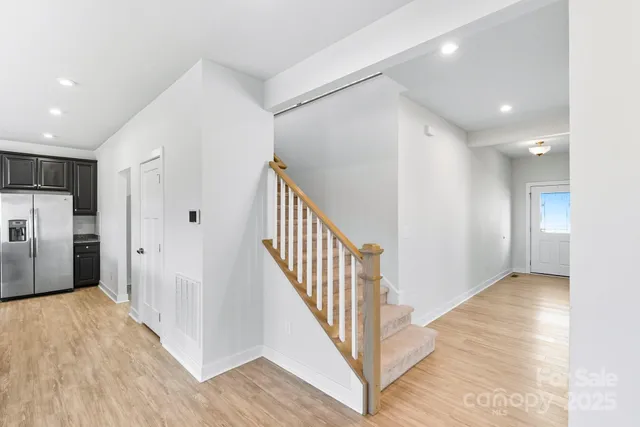 a view of a hallway with wooden floor and staircase