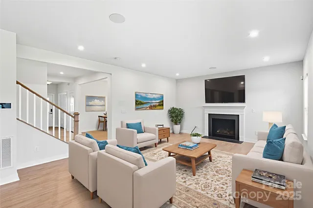 a living room with furniture a fireplace and a flat screen tv
