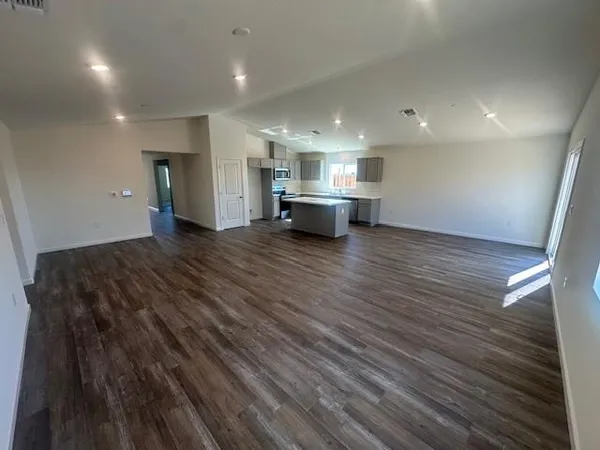 a view of empty room with wooden floor and fireplace
