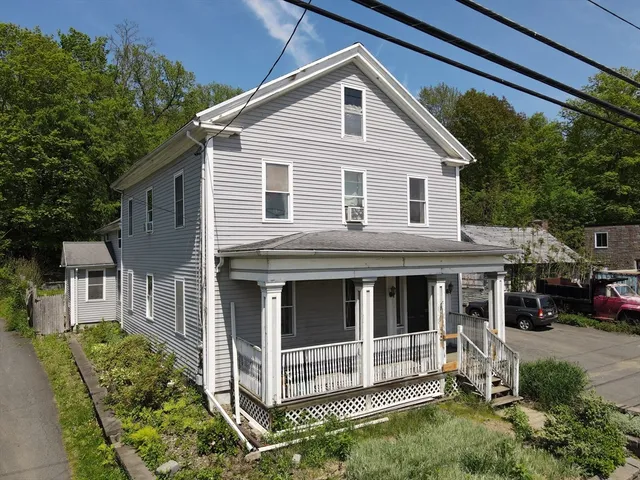 a view of a house with a yard and potted plants