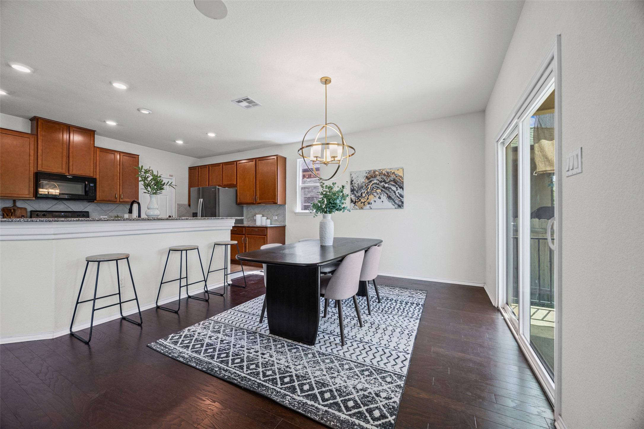 2471 Sunrise Road, Unit 64 Round Rock, TX 78664 - Photo 5 of 32 An open-concept living space presents a modern kitchen flowing seamlessly into a dining area, featuring sleek dark wood flooring.