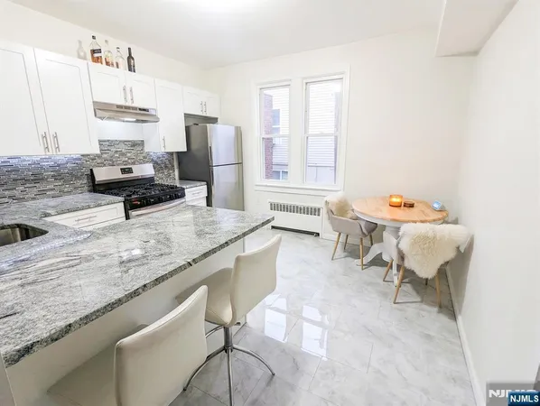 a kitchen with a sink stove and chairs