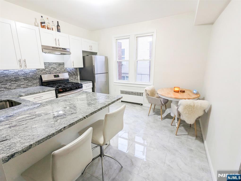 582 60th Street West New York, NJ 07093 - Photo 4 of 10 a kitchen with a sink stove and chairs