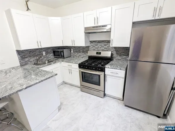 a kitchen with a stove a refrigerator and a sink