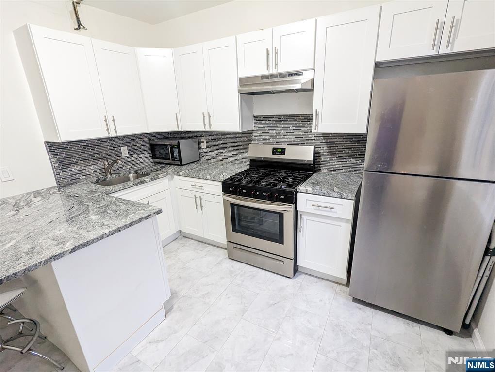 582 60th Street West New York, NJ 07093 - Photo 5 of 10 a kitchen with a stove a refrigerator and a sink