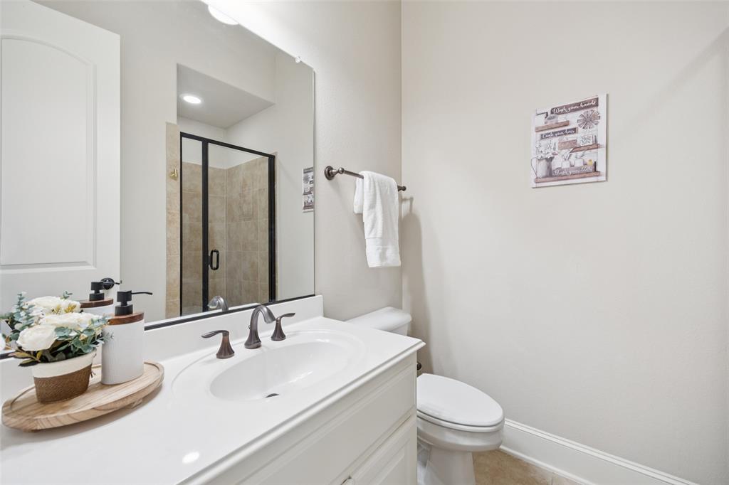 4020 Chama Street Prosper, TX 75078 - Photo 22 of 40 a bathroom with a toilet sink and mirror