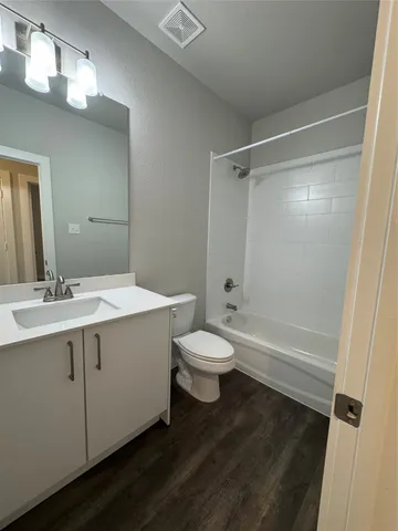 a bathroom with a sink a toilet a mirror and shower