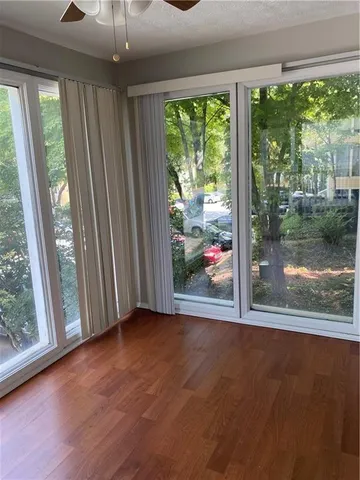 an empty room with wooden floor and outdoor view