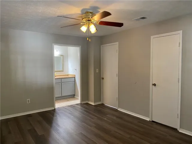 a view of a room with wooden floor and a ceiling fan