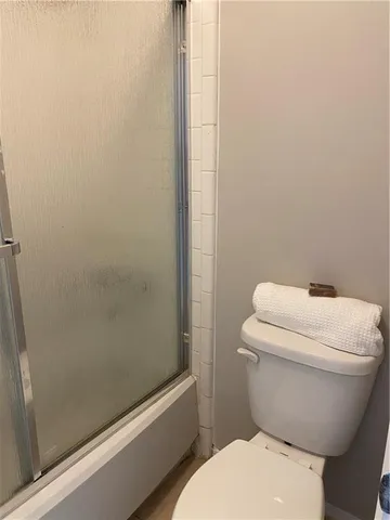 a white toilet sitting next to a bath tub