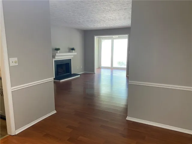 an empty room with wooden floor cabinet and windows