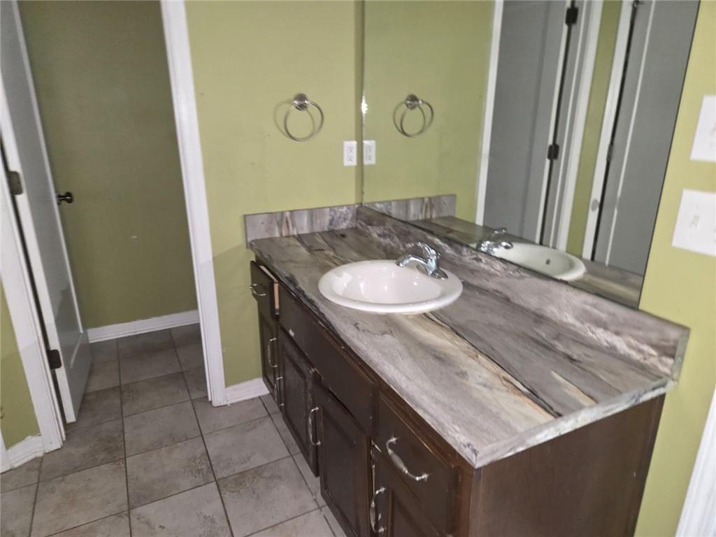 141 McRae Street Atmore, AL 36502 - Photo 19 of 25 a bathroom with a granite countertop sink a mirror and a vanity