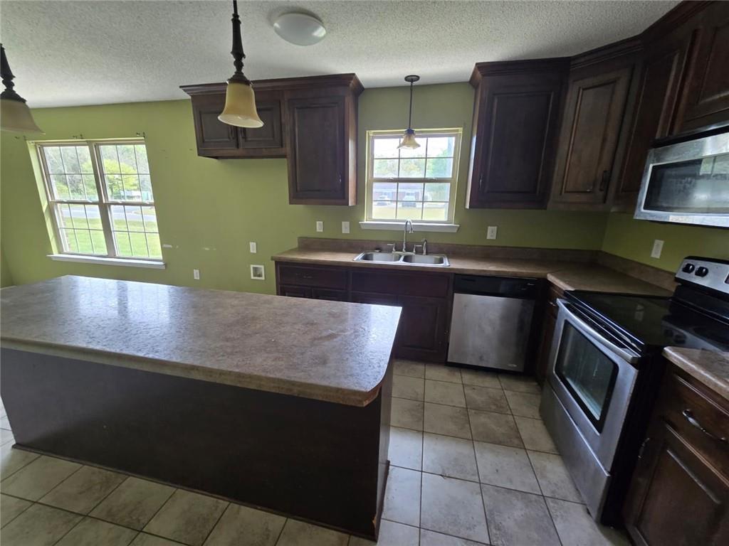 141 McRae Street Atmore, AL 36502 - Photo 22 of 25 a kitchen with kitchen island granite countertop a sink a counter top space appliances and cabinets