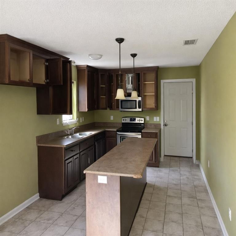 141 McRae Street Atmore, AL 36502 - Photo 4 of 25 a kitchen with stainless steel appliances granite countertop a stove and a refrigerator