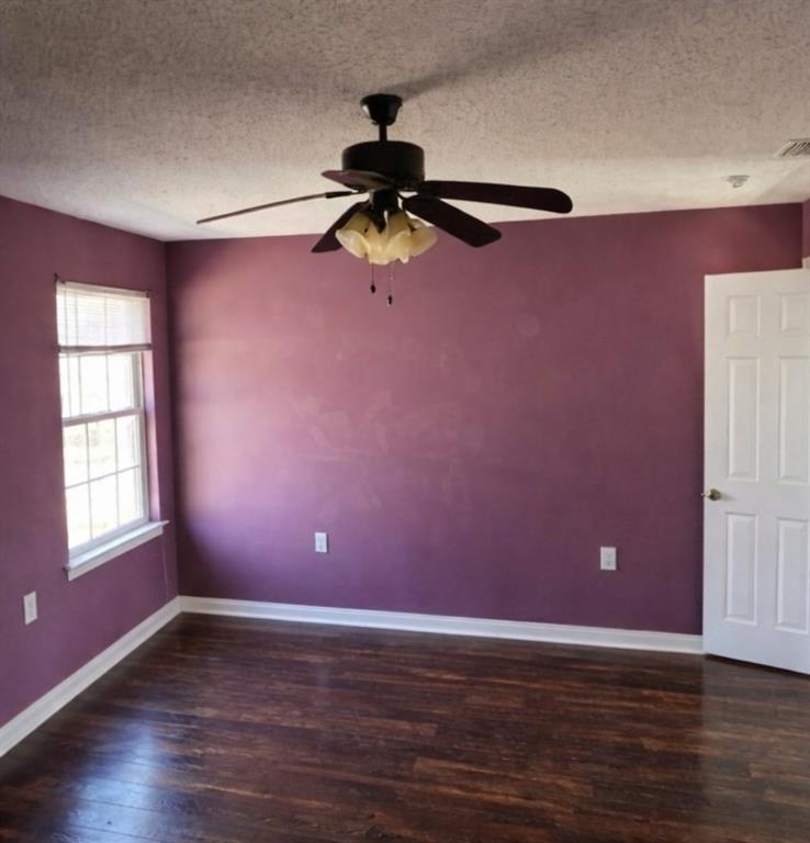 141 McRae Street Atmore, AL 36502 - Photo 5 of 25 a view of an empty room with window and wooden floor