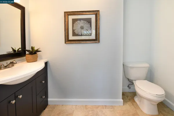 a bathroom with a granite countertop toilet sink and mirror