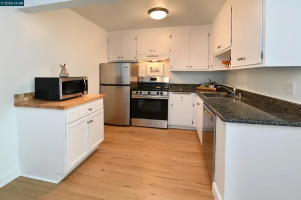 a kitchen with stainless steel appliances granite countertop a stove a sink and a refrigerator