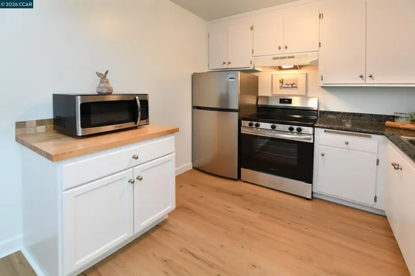a kitchen with cabinets appliances and a wooden floor