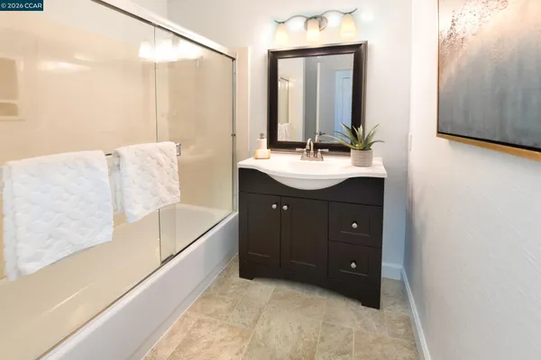 a bathroom with a tub sink and mirror
