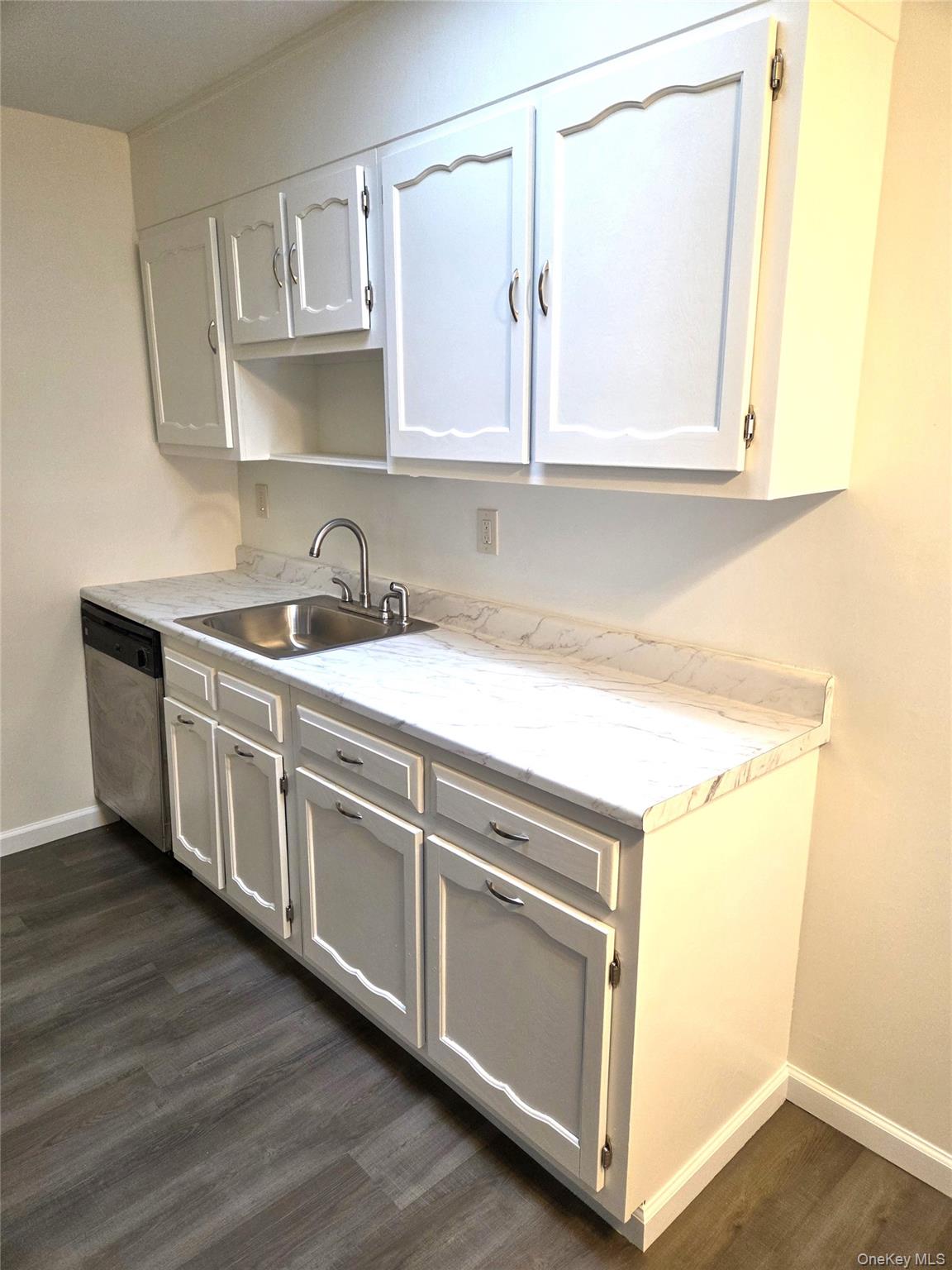 186 C Ventry Court Ridge, NY 11961 - Photo 12 of 25 The Kitchen Offers Lots Of Storage Cabinetry, Accent Shelf Above The Sink, Ample Counter/Serving Space & An Updated Stainless Steel Dishwasher.