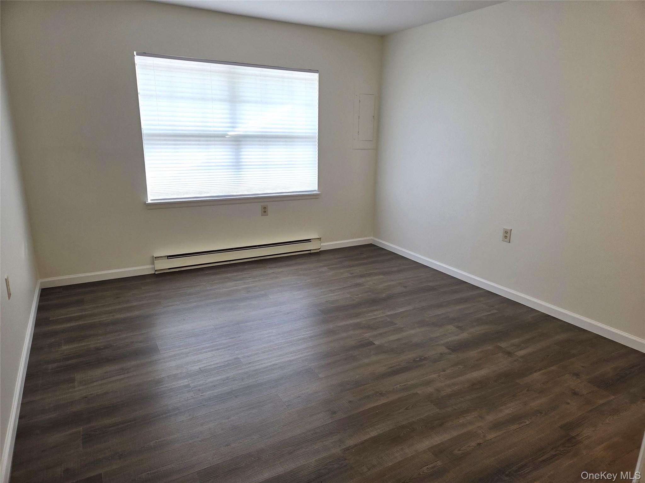 186 C Ventry Court Ridge, NY 11961 - Photo 14 of 25 an empty room with wooden floor and windows