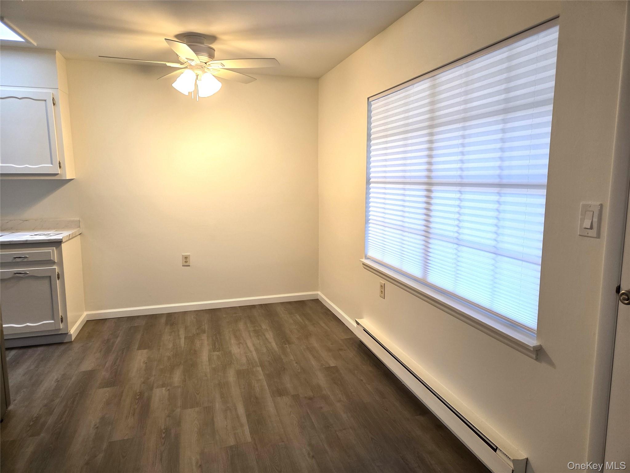 186 C Ventry Court Ridge, NY 11961 - Photo 9 of 25 a view of an empty room with a window and wooden floor