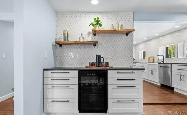a kitchen with stainless steel appliances cabinets and a wooden floor