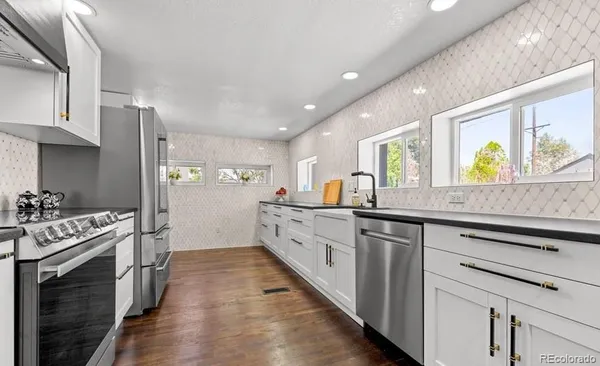 a kitchen with stainless steel appliances a stove top oven and sink