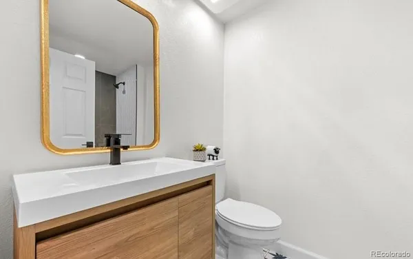 a bathroom with a sink a toilet and mirror