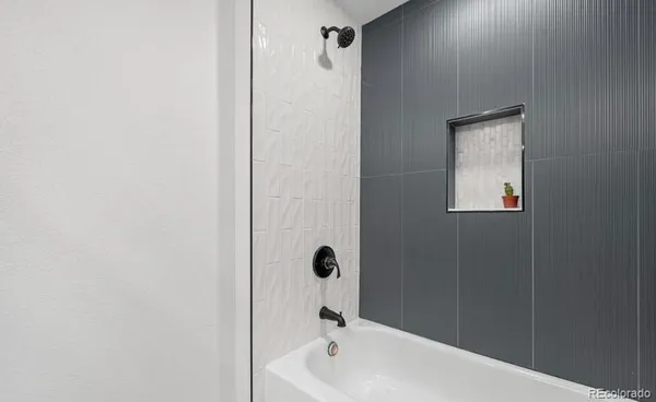 a bathroom with a tub shower and a sink