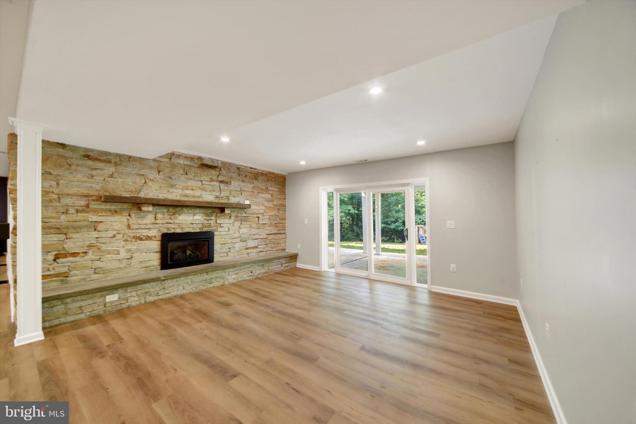 900 Stags Head Road Towson, MD 21286 - Photo 43 of 83 an empty room with wooden floor fireplace and windows