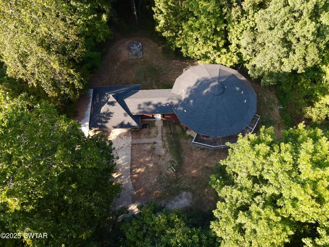 an aerial view of a house with yard and swimming pool