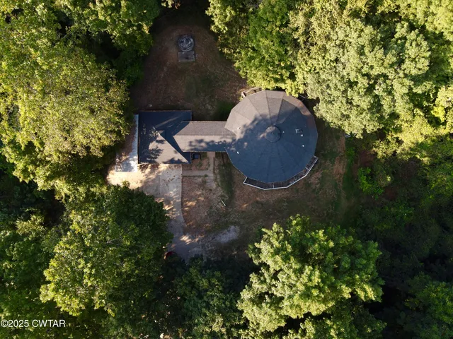 an aerial view of a house with a yard and large tree