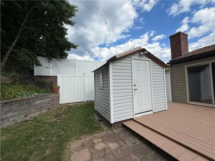 a view of backyard with barbeque grill and wooden fence