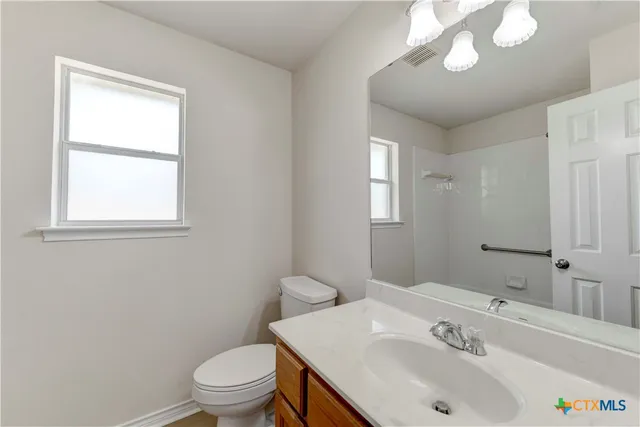 a bathroom with a sink a toilet and a mirror