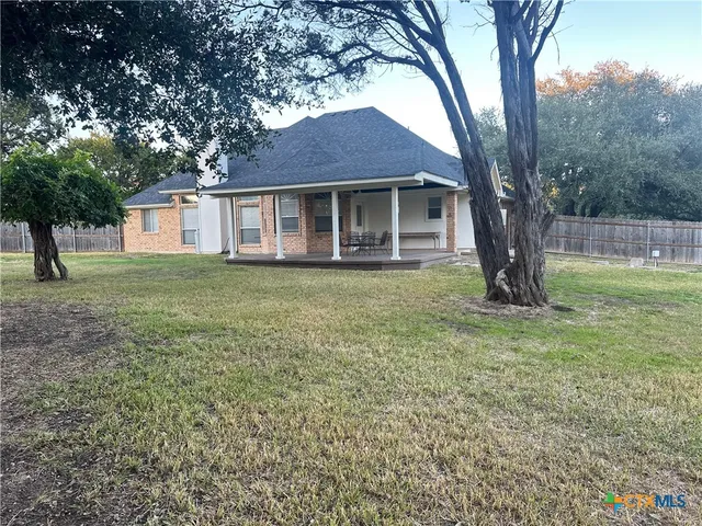 a view of a yard in front of a house with large tree